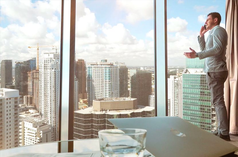 Man Standing in Office Building Window
